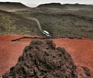 Un autboús cruzando el paisaje lunar de Timanfaya