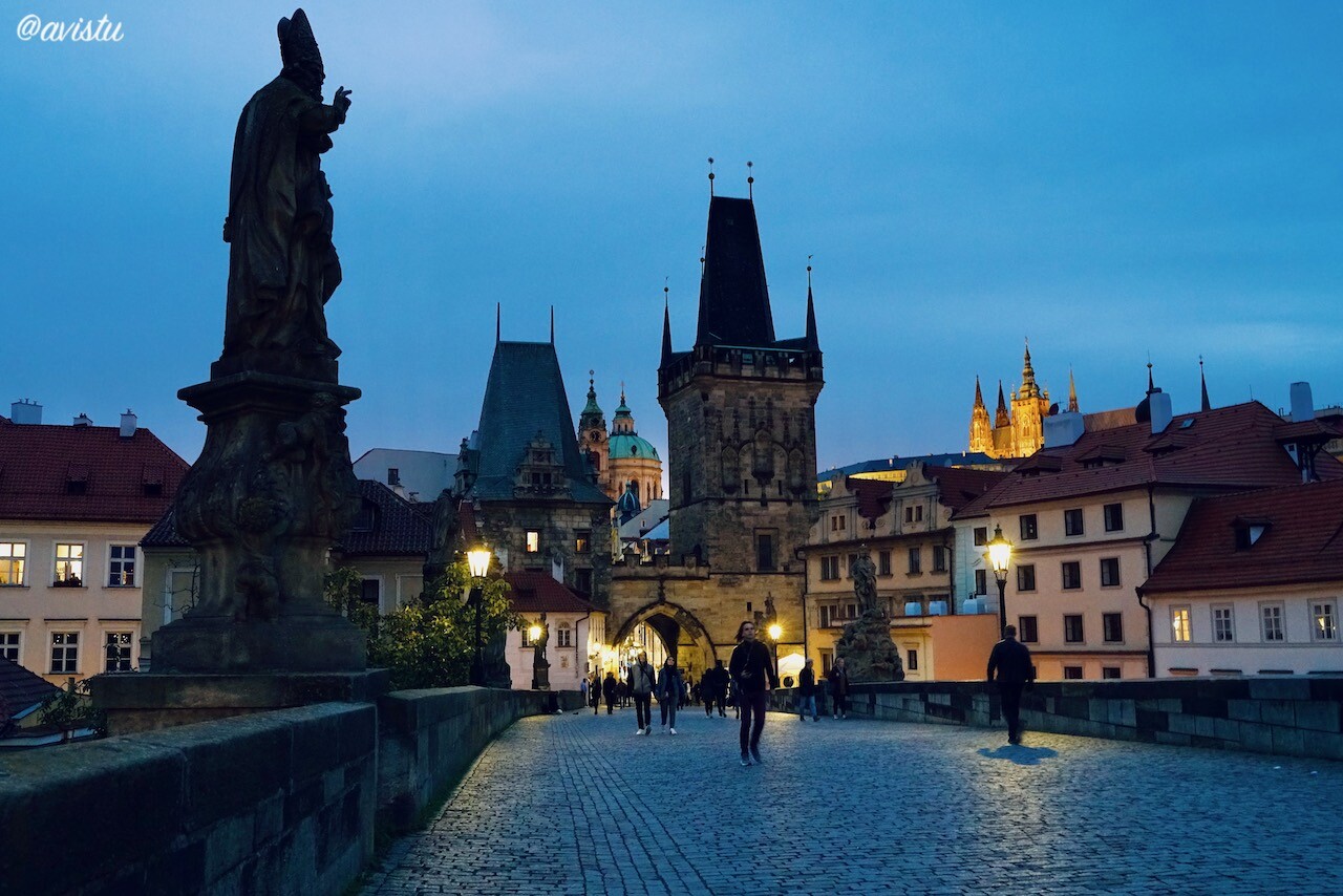 Atardecer en el Puente de Carlos en Praga con vistas a la Iglesia de San Nicolás, la Torre y la Catedral [(c)Foto: @avistu]