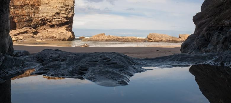 La Playa de las Catedrales desde el interior de una cueva en el acantilado [CC Foto: wolfgang.mller54/Wikimedia Commons]