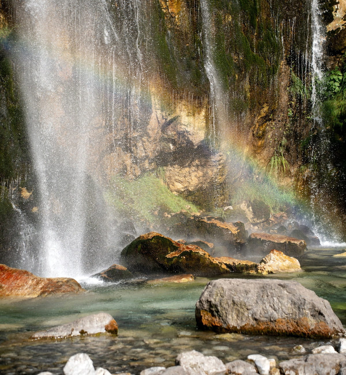 Un arcoiris reflejado en las aguas que cayen sobre el Ojo Azul de Theth
